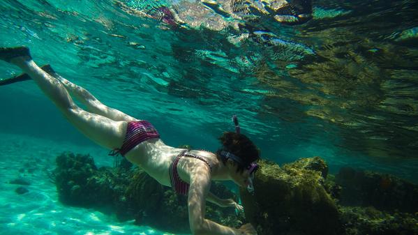 Girl snorkelling through clear water in Belize