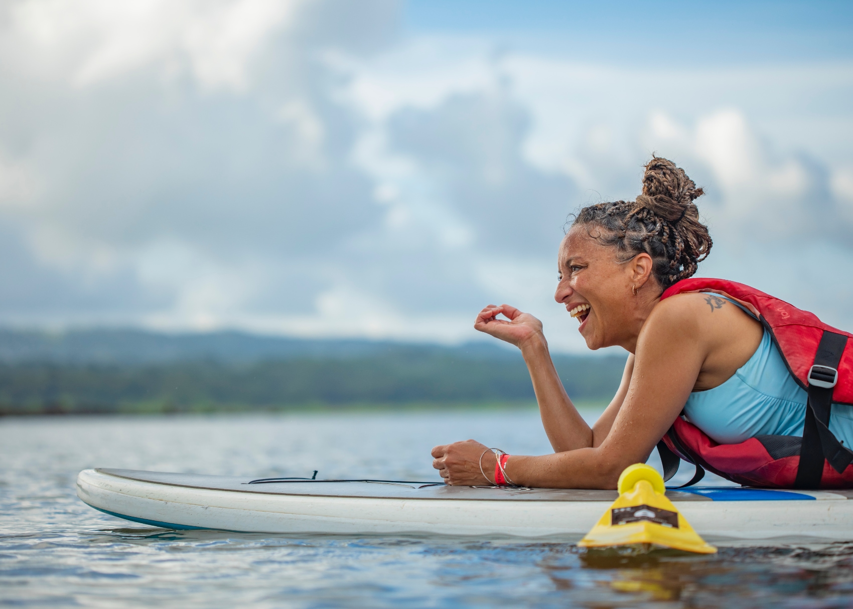 a laughing woman takes time to rest between paddling in the Costa Rican surf