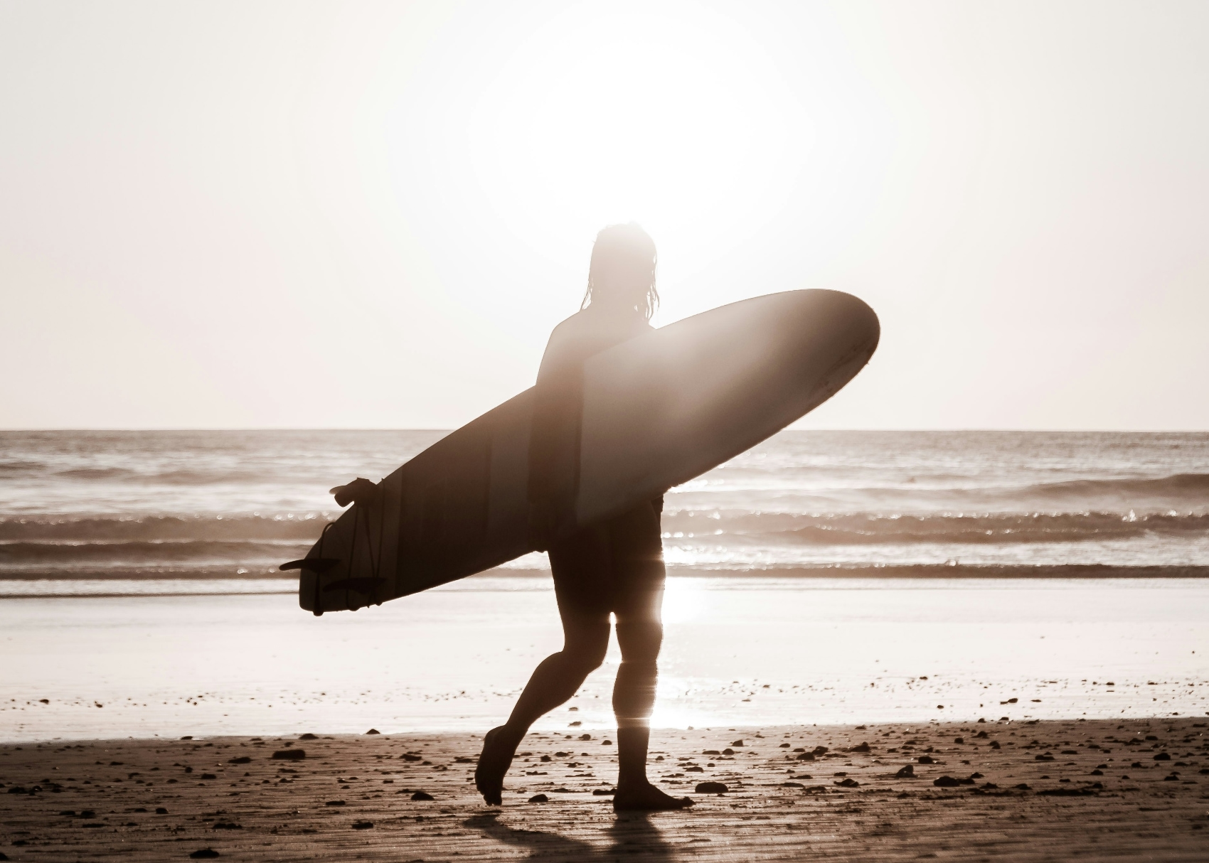 a bohemian surfer holding his board against the backdrop of Santa Teresa