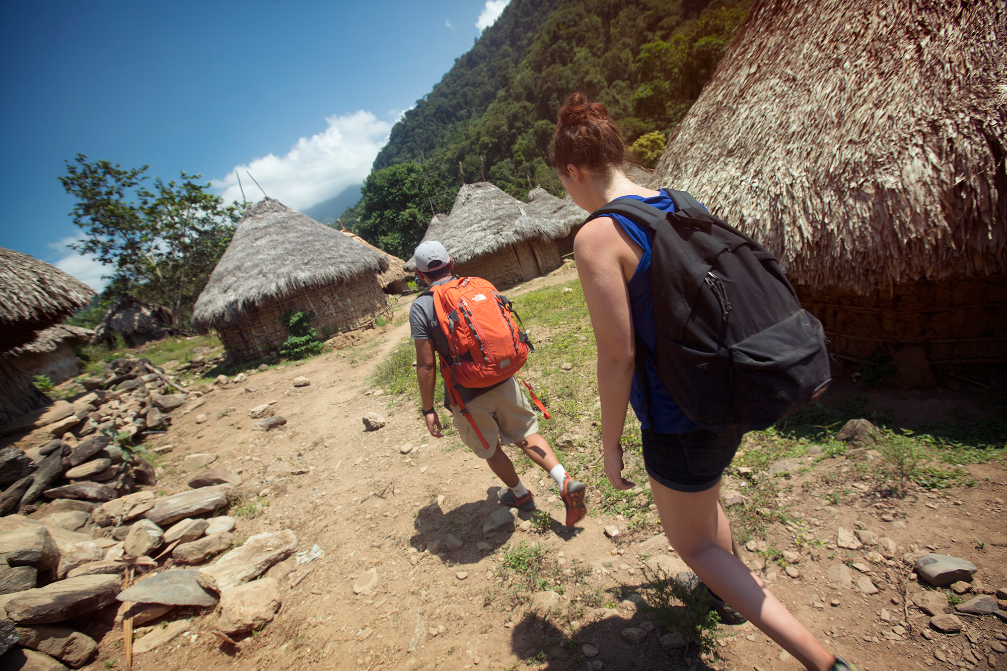 The path follows along the fertile land beside the homes of local communities.